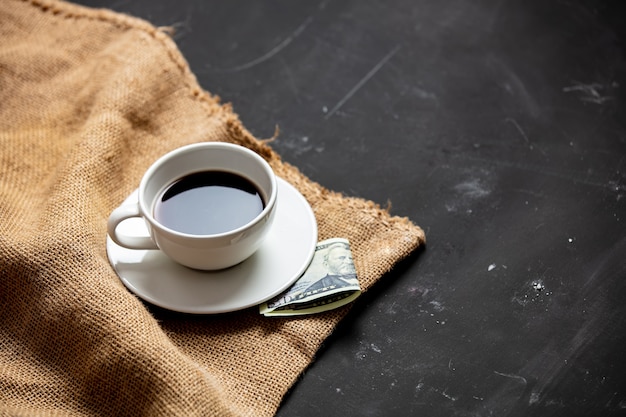 Tasse schwarzen Kaffee und Bezahlung auf dem Tisch
