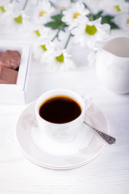 Tasse schwarzen Kaffee und Pralinen