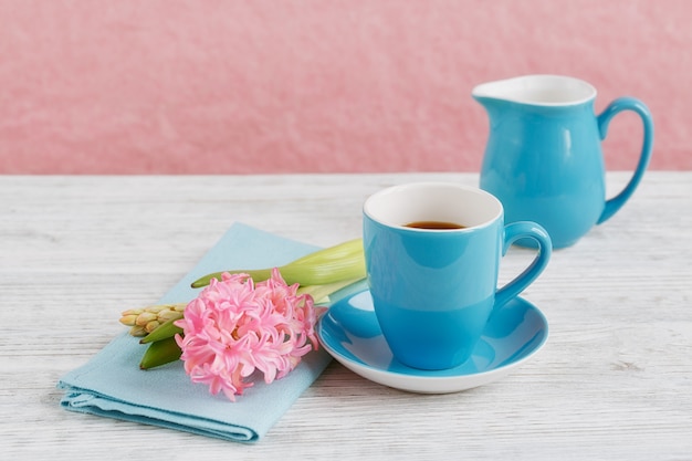 Tasse schwarzen Kaffee und rosa Blume