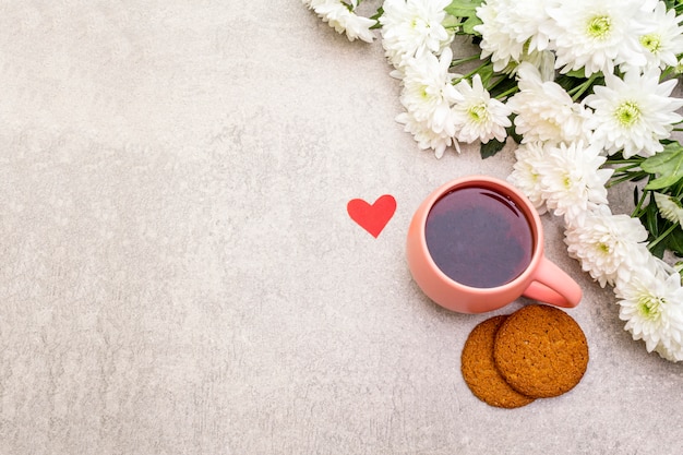 Tasse schwarzen Tee, Haferkekse und Bouquet von Chrysanthemen