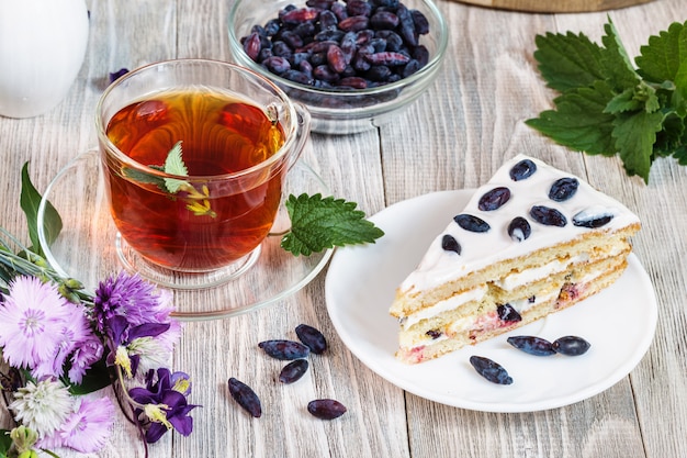 Tasse Tee, Kuchen auf Teller auf Holztisch