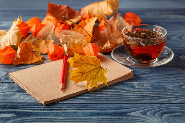 Tasse Tee mit Herbstdekor auf Holztisch