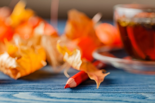 Tasse Tee mit Herbstdekor auf Holztisch