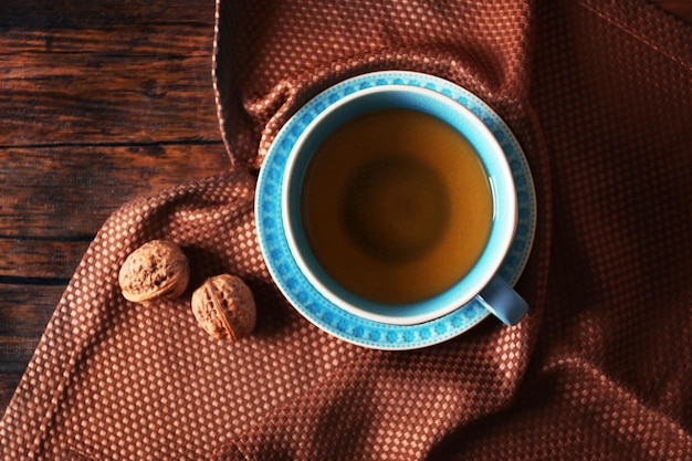 Tasse Tee mit Herbstdekor auf Holztisch