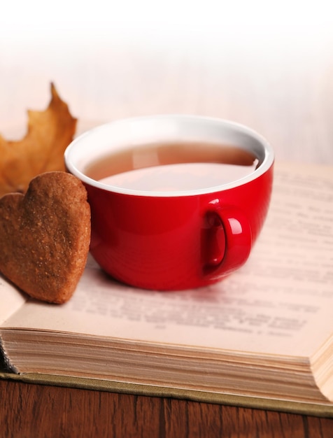 Tasse Tee mit Herbstdekor auf Holztisch