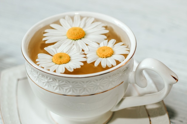 Tasse Tee mit Kamillennahaufnahme. Ein Kräutergetränk für Seelenfrieden.