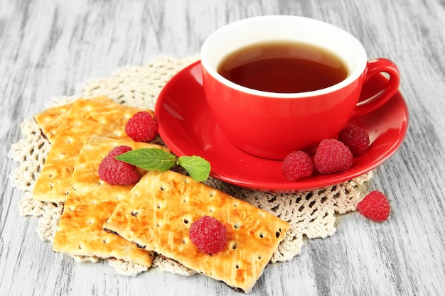 Tasse Tee mit Kekse und Himbeeren auf dem Tisch in Nahaufnahme