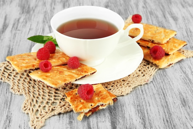 Tasse Tee mit Kekse und Himbeeren auf dem Tisch in Nahaufnahme