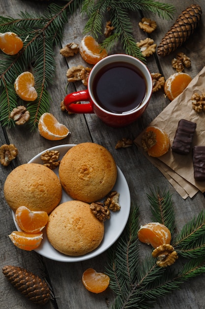 Tasse Tee mit Keksen, Holztisch, Süßigkeiten