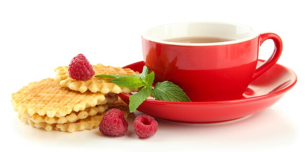 Tasse Tee mit Keksen und Himbeeren lokalisiert auf Weiß