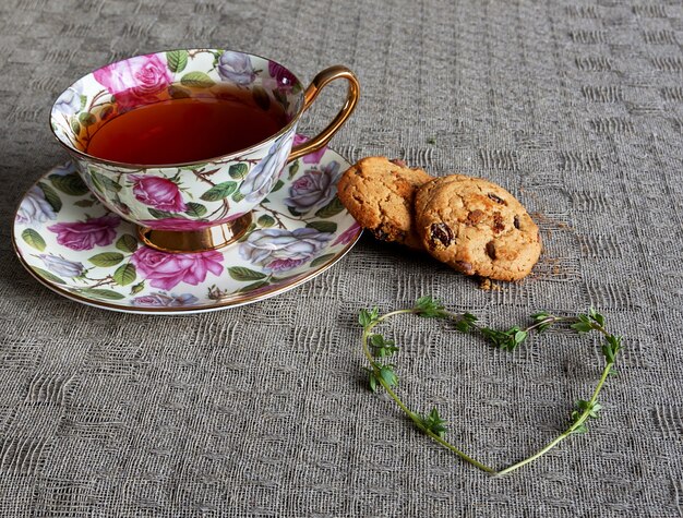 Tasse Tee mit Keksen und Thymianherz