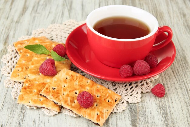 Tasse Tee mit Plätzchen und Himbeeren auf Tischnahaufnahme