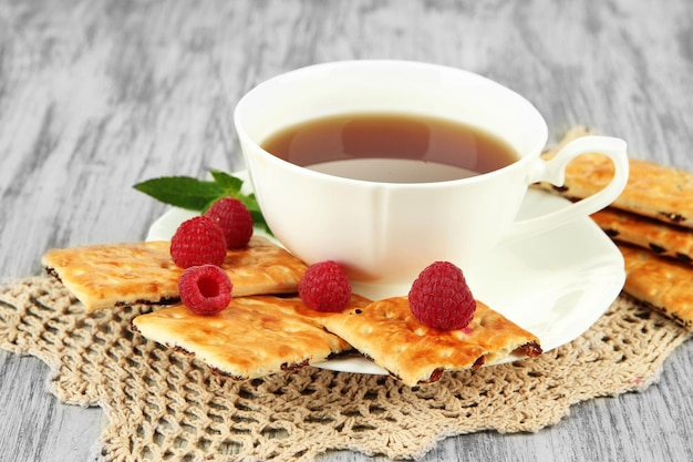 Tasse Tee mit Plätzchen und Himbeeren auf Tischnahaufnahme