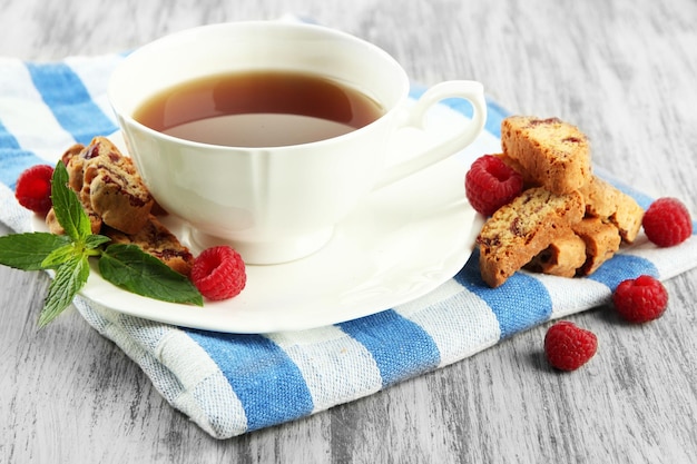 Tasse Tee mit Plätzchen und Himbeeren auf Tischnahaufnahme