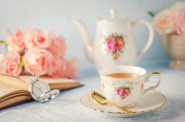 Foto tasse tee mit teekanne und blumen mit weinleseton