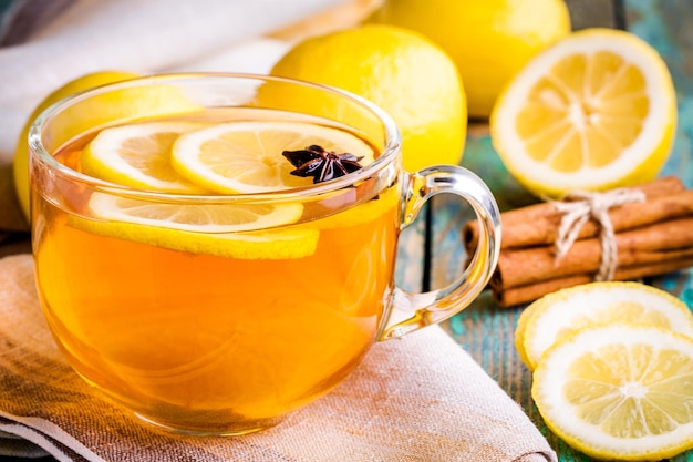 Tasse Tee mit Zitrone und Anis auf rustikalem Tisch