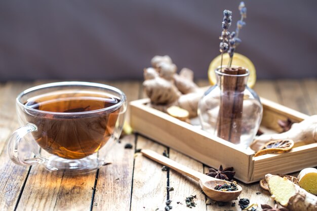 Tasse Tee und aromatische Elemente auf Holztisch