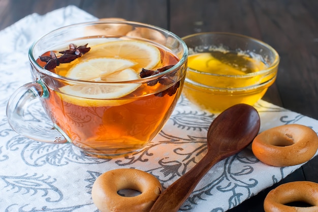 Tasse Tee und Bagel auf einem Holztisch.