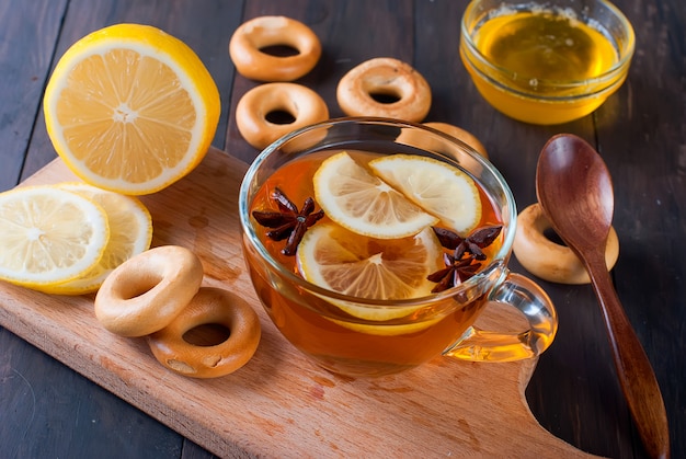 Tasse Tee und Bagel auf einem Holztisch.