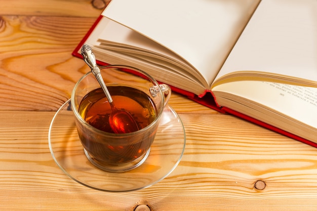 Tasse Tee und Bücher auf Holz