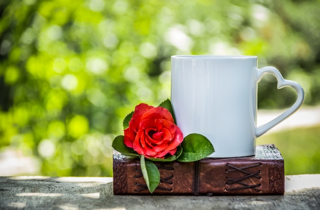 Tasse Tee und eine rote Rose.