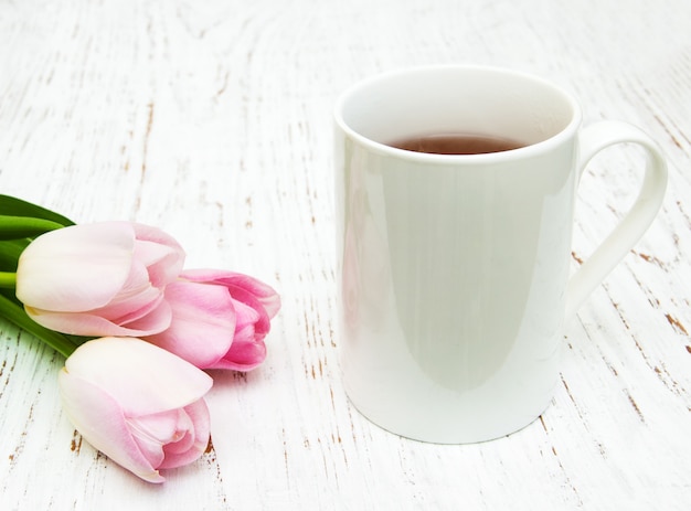 Tasse Tee und rosa Tulpen