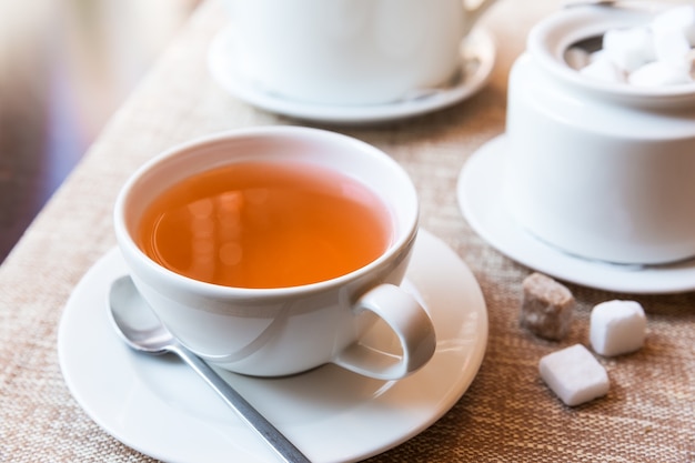 Tasse Tee und Teekanne auf dem Tisch
