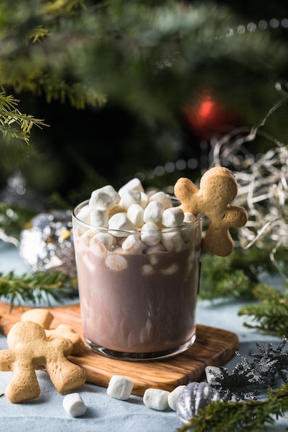 Tassen heiße Schokolade mit Marshmallows und Zimt auf braunem Holzhintergrund