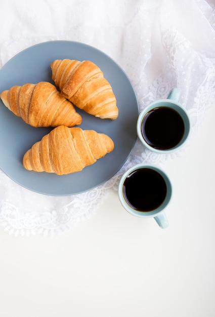 Tassen Kaffee mit Croissants