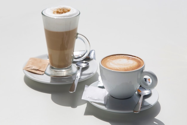 Tassen Kaffee mit hellem Sonnenlicht auf dem Tisch