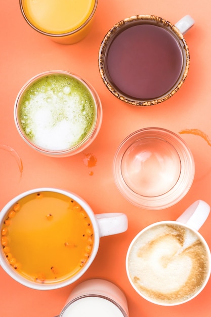 Tassen Kaffee, Tee, Saft und Wasser. Morgengetränke für verschiedene Vorlieben.