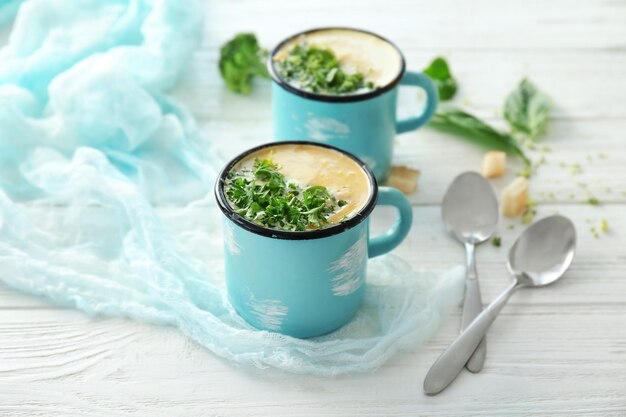 Tassen mit Brokkoli-Cheddar-Suppe auf dem Tisch