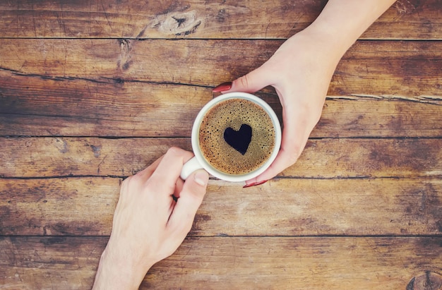 Tassen mit einem Kaffee in den Händen von Männern und Frauen. Selektiver Fokus