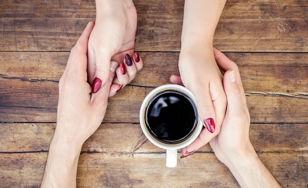 Tassen mit einem Kaffee in den Händen von Männern und Frauen. Selektiver Fokus