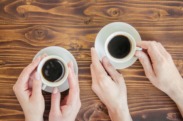 Tassen mit einem kaffee in den händen von männern und frauen.