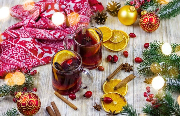 Tassen mit heißem Glühwein auf einem hölzernen Hintergrund. Neujahrskonzept