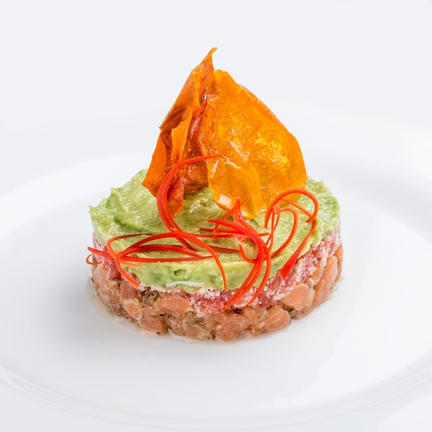 Tatar mit Lachs und Avocado-Mousse auf weißem Hintergrund