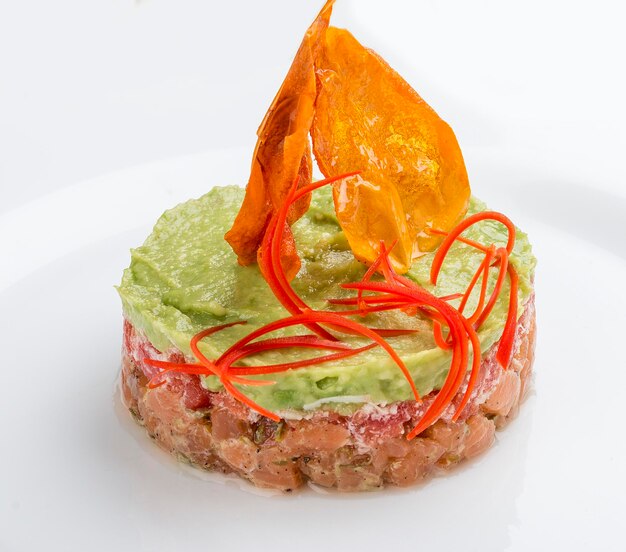 Tatar mit Lachs und Avocado-Mousse auf weißem Hintergrund