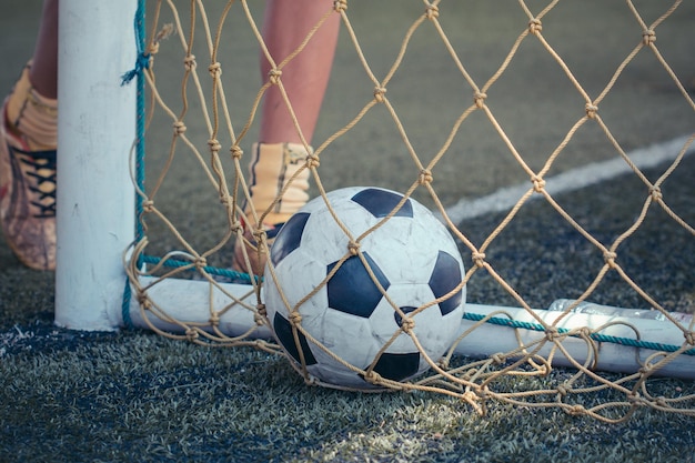 Táticas de bola de futebol de meninos no campo de grama com cone