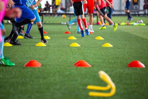 Táticas de bola de futebol no campo de grama com cone para treinar a Tailândia em segundo plano Treinar crianças na academia de futebol