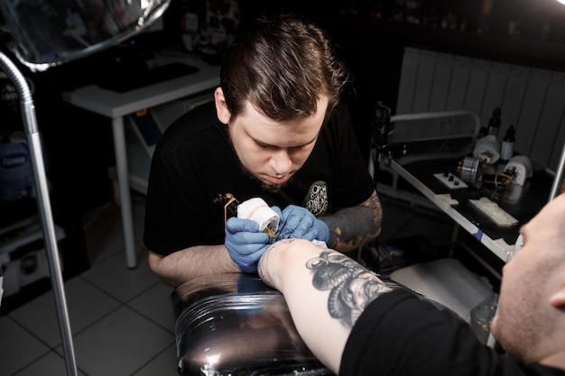 Foto tattoo master en el trabajo hace dibujar a mano