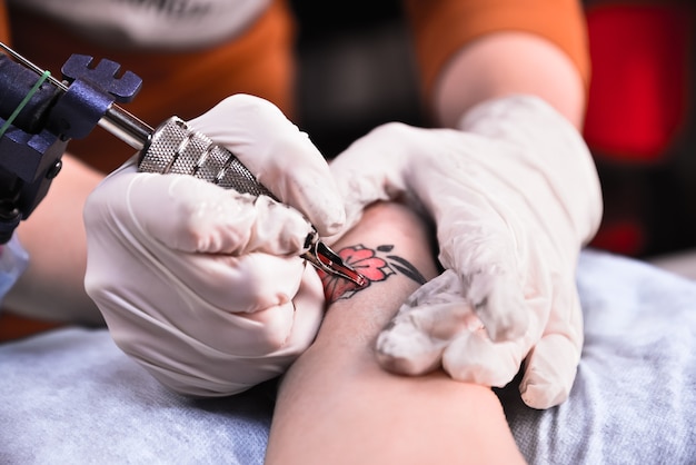 Tattooer mostrando o processo de fazer uma tatuagem.
