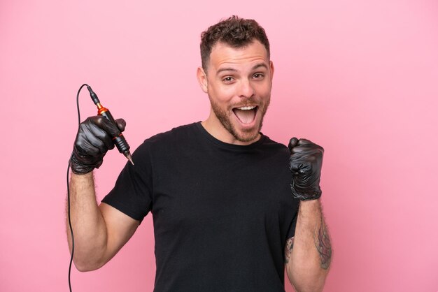 Tatuador brasileiro homem isolado no fundo rosa comemorando uma vitória na posição de vencedor