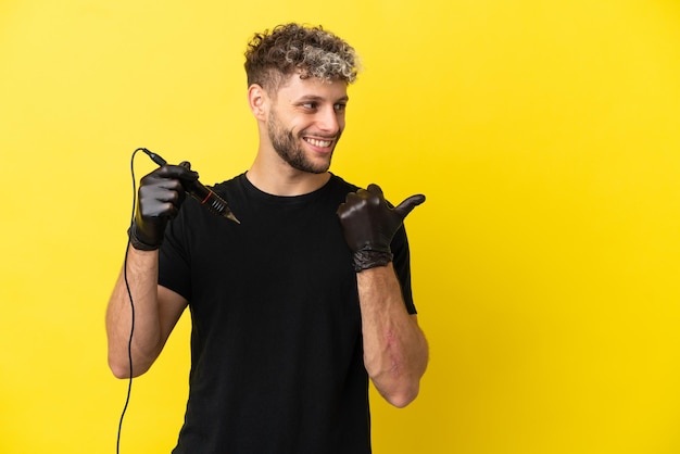 Tatuador homem caucasiano isolado em fundo amarelo apontando para o lado para apresentar um produto