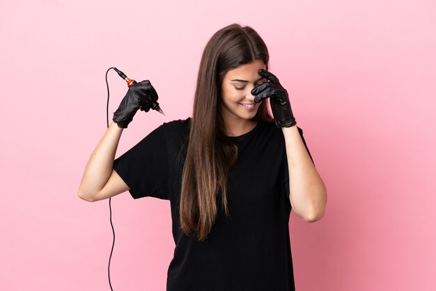 Tatuador mujer aislada sobre fondo rosa riendo