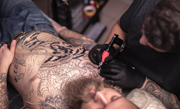 Tatuador profesional hace un tatuaje en el estudio.