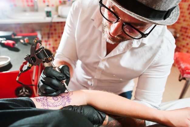 Tatuador profesional hace tatuaje