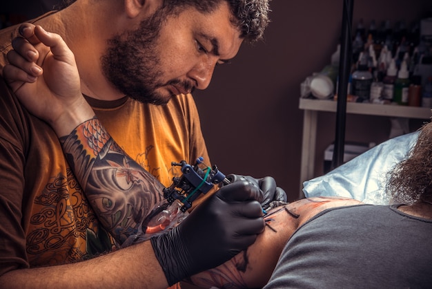 Tatuador profissional faz fotos de tatuagem em estúdio de tatuagem