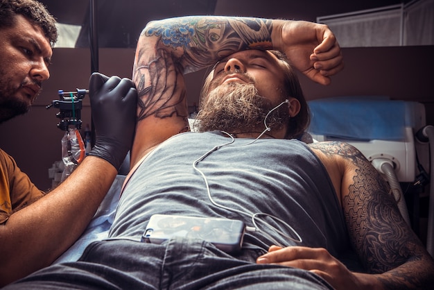 Tatuador profissional faz tatuagem legal no estúdio de tatuagem. / tatuador profissional faz tatuagem no estúdio de tatuagem.