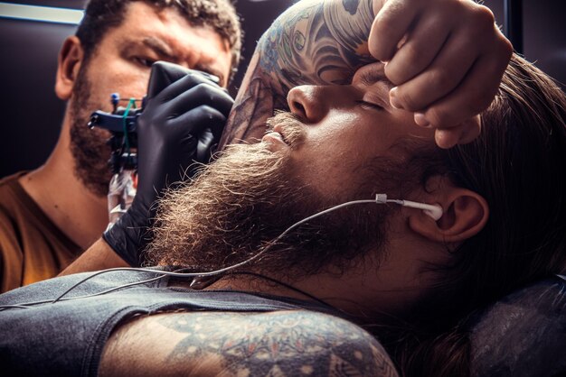 Tatuador profissional no trabalho no estúdio de tatuagem